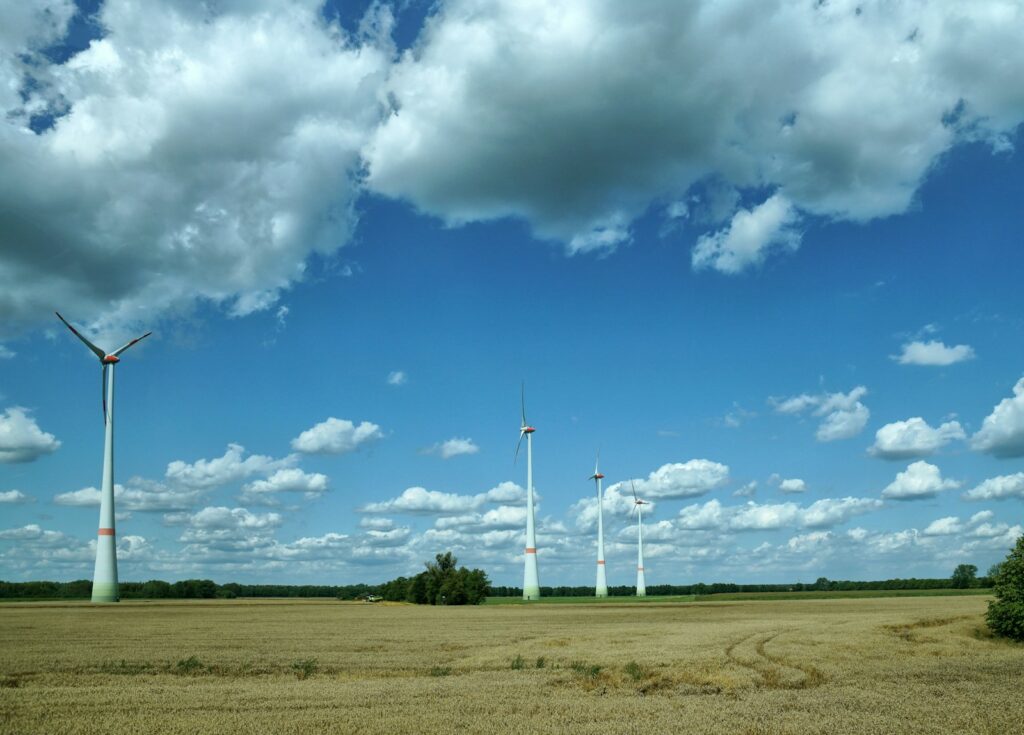 a field with wind turbines in the distance