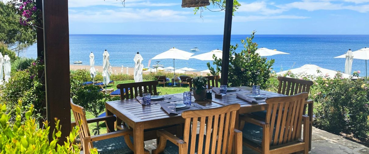 brown wooden table with chairs and table on beach during daytime