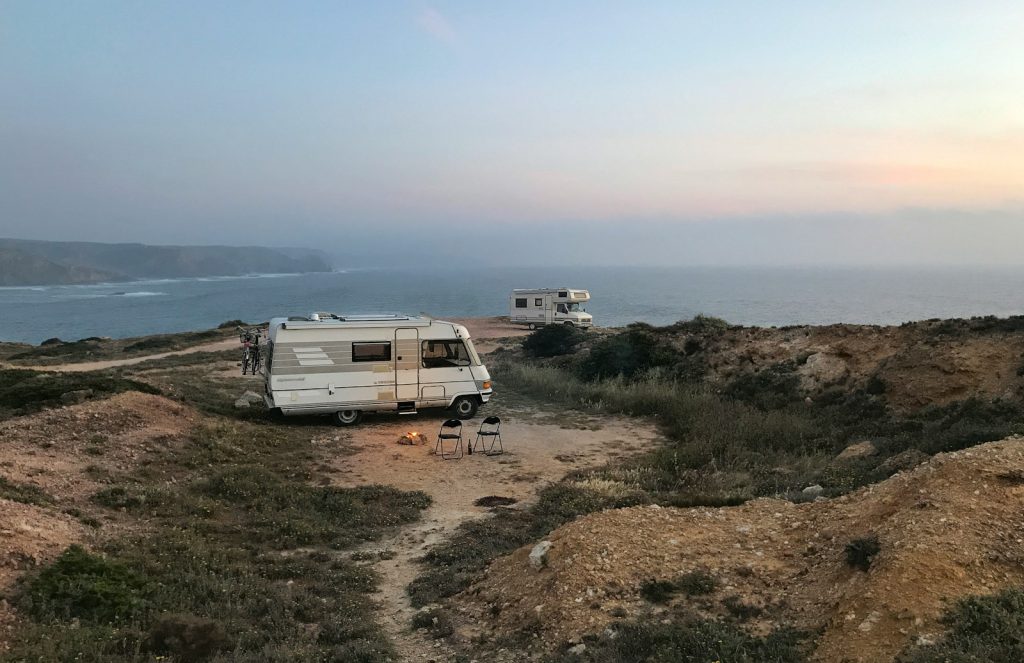 white and brown rv on brown field under blue sky during daytime