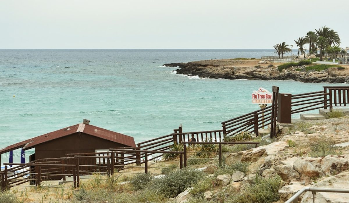 a wooden walkway leading to a beach next to the ocean