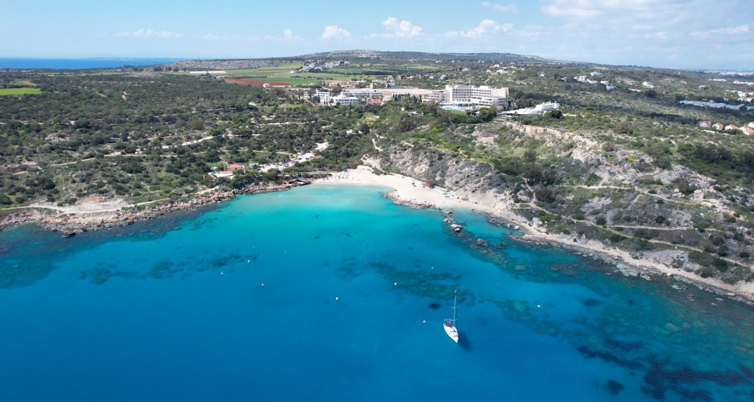 an aerial view of a beach with a boat in the water